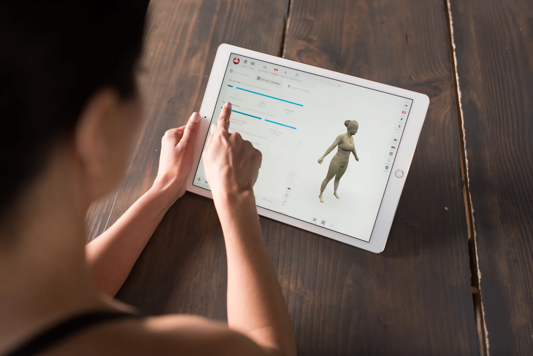 VeCura advisor reviewing a Styku 3D body scan report on a tablet