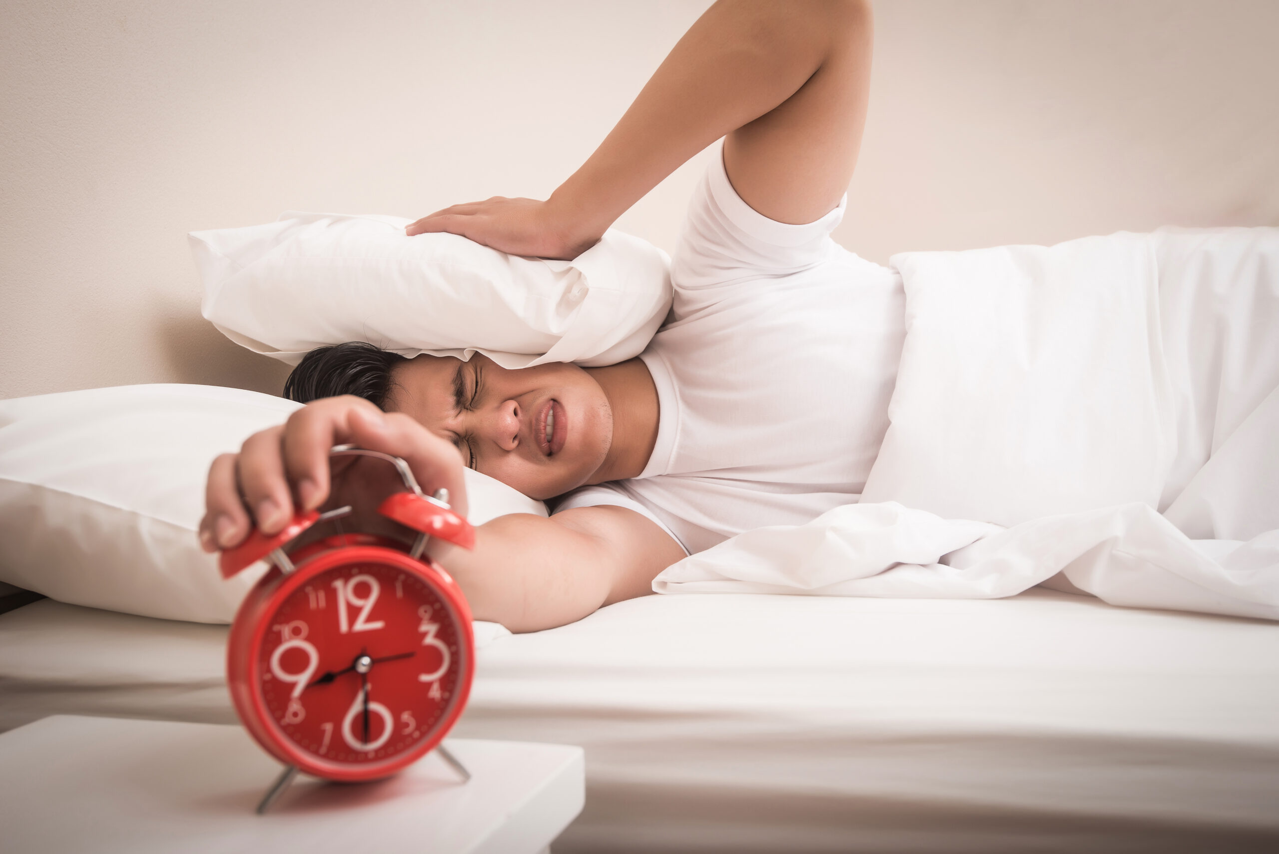 Man hand turns off the alarm clock waking up at morning .
